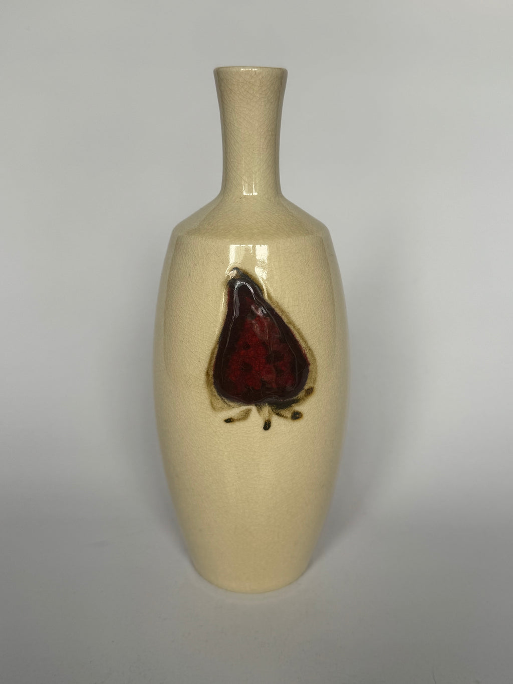 Beige ceramic vase with a red and black design on a gray background