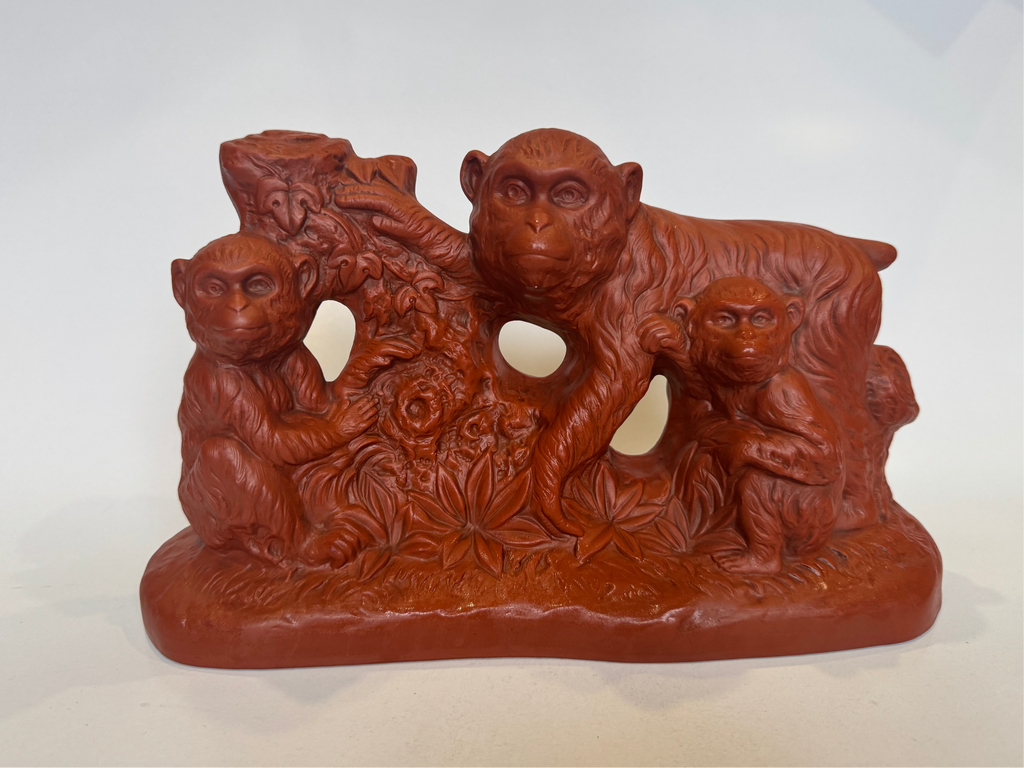 Brown ceramic sculpture of monkeys on a white background