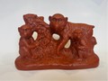 Brown ceramic sculpture of monkeys on a white background