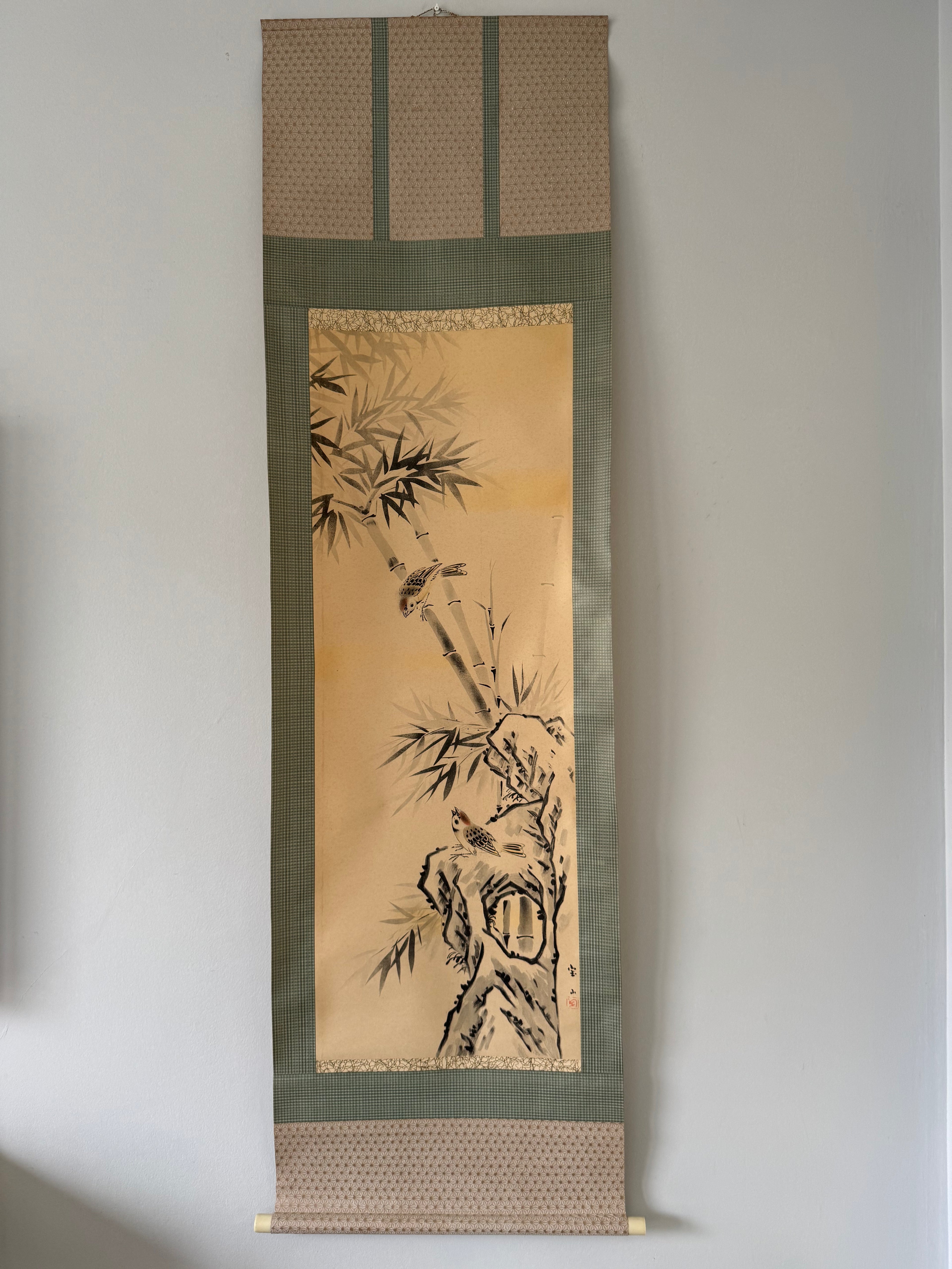Traditional Japanese scroll with bamboo design on a plain wall