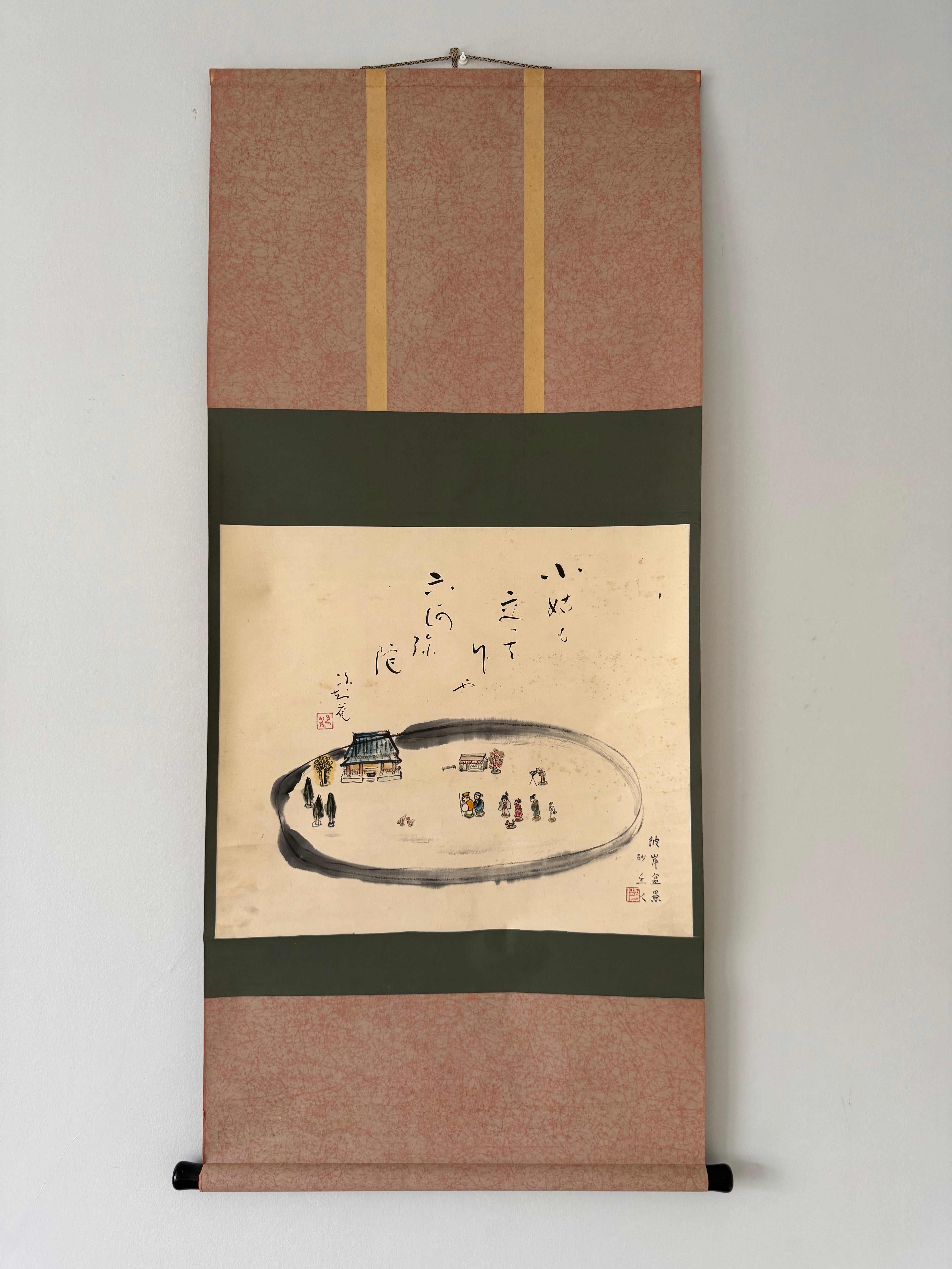 Traditional Japanese scroll with landscape and characters on a plain background