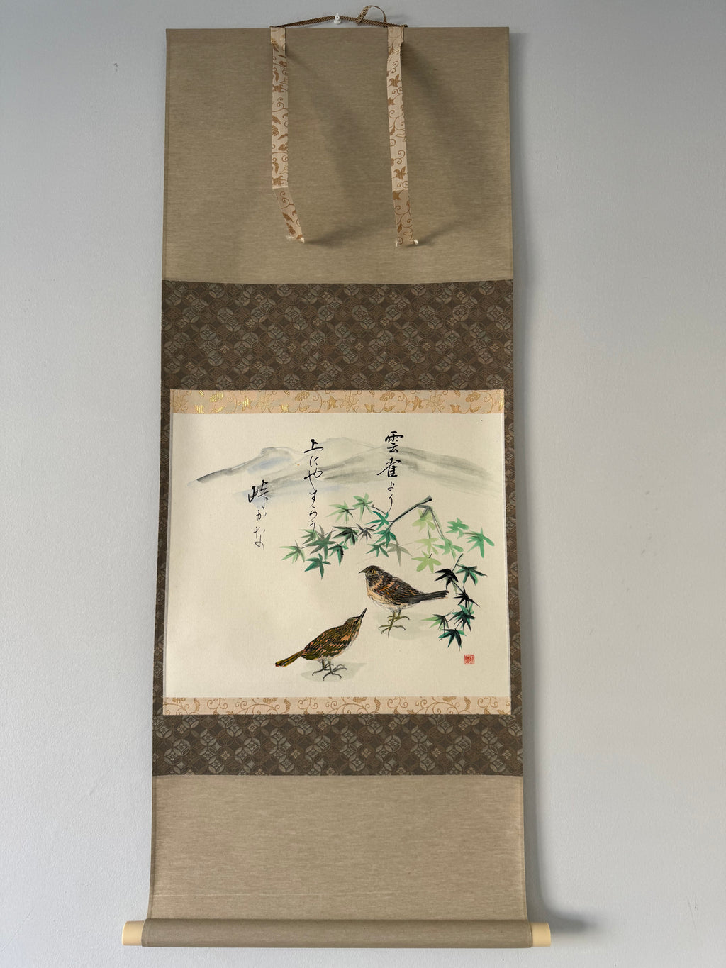 Traditional Japanese scroll with bird and bamboo design on a plain background
