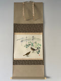 Traditional Japanese scroll with bird and bamboo design on a plain background