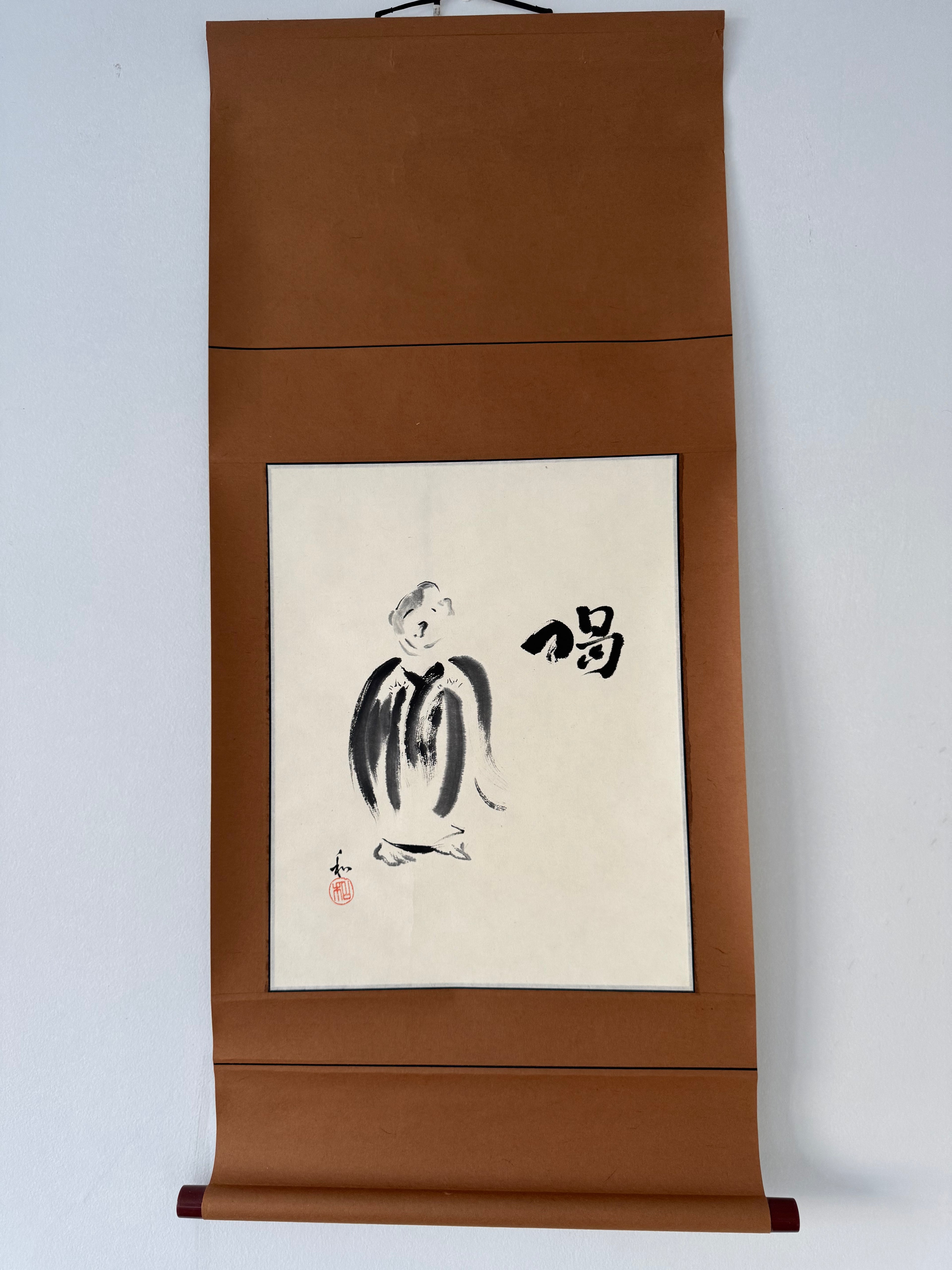 Traditional japanes ink painting on a vertical scroll with a brown frame against a white background