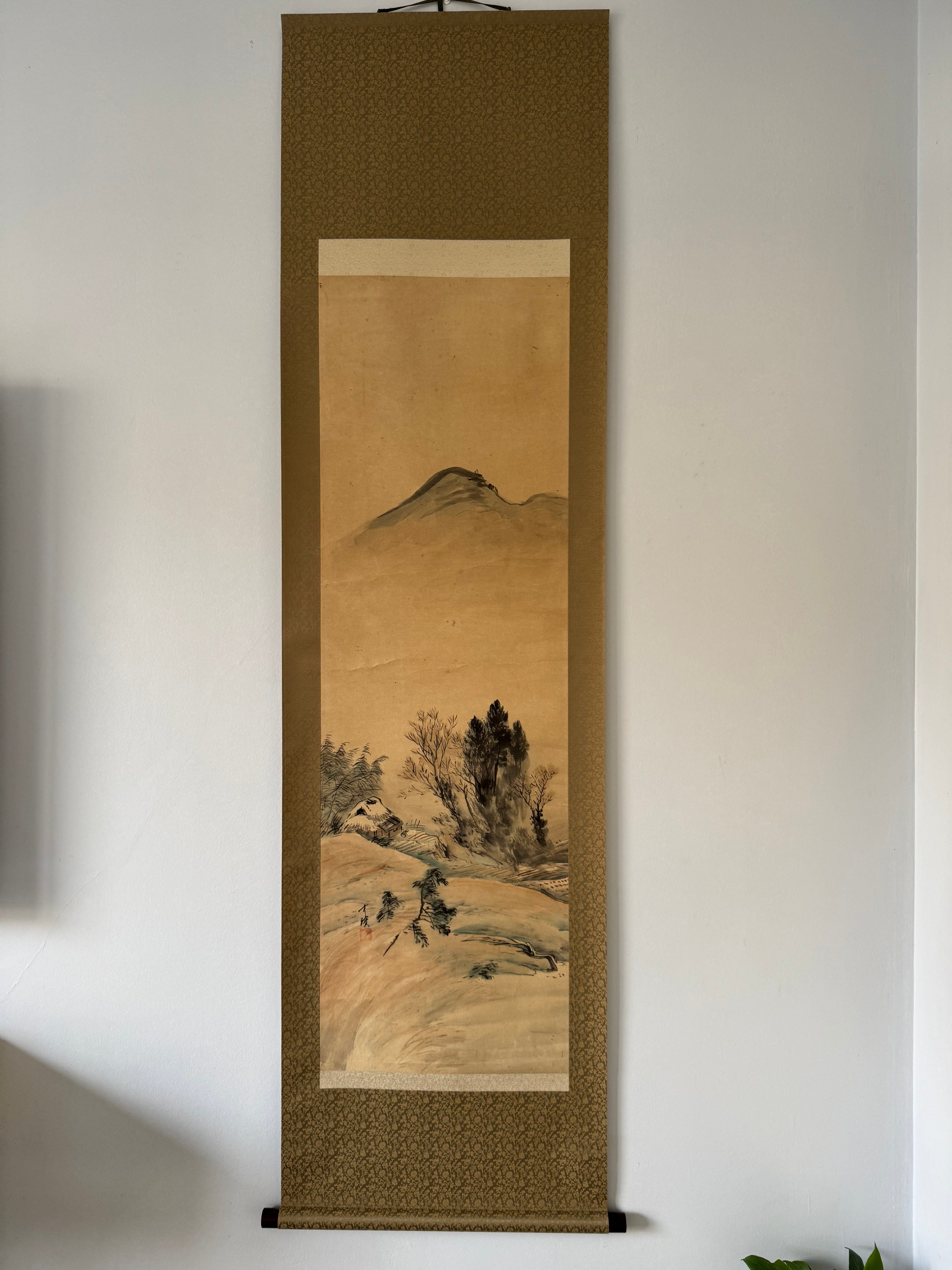 Traditional landscape painting in a wooden frame on a white wall