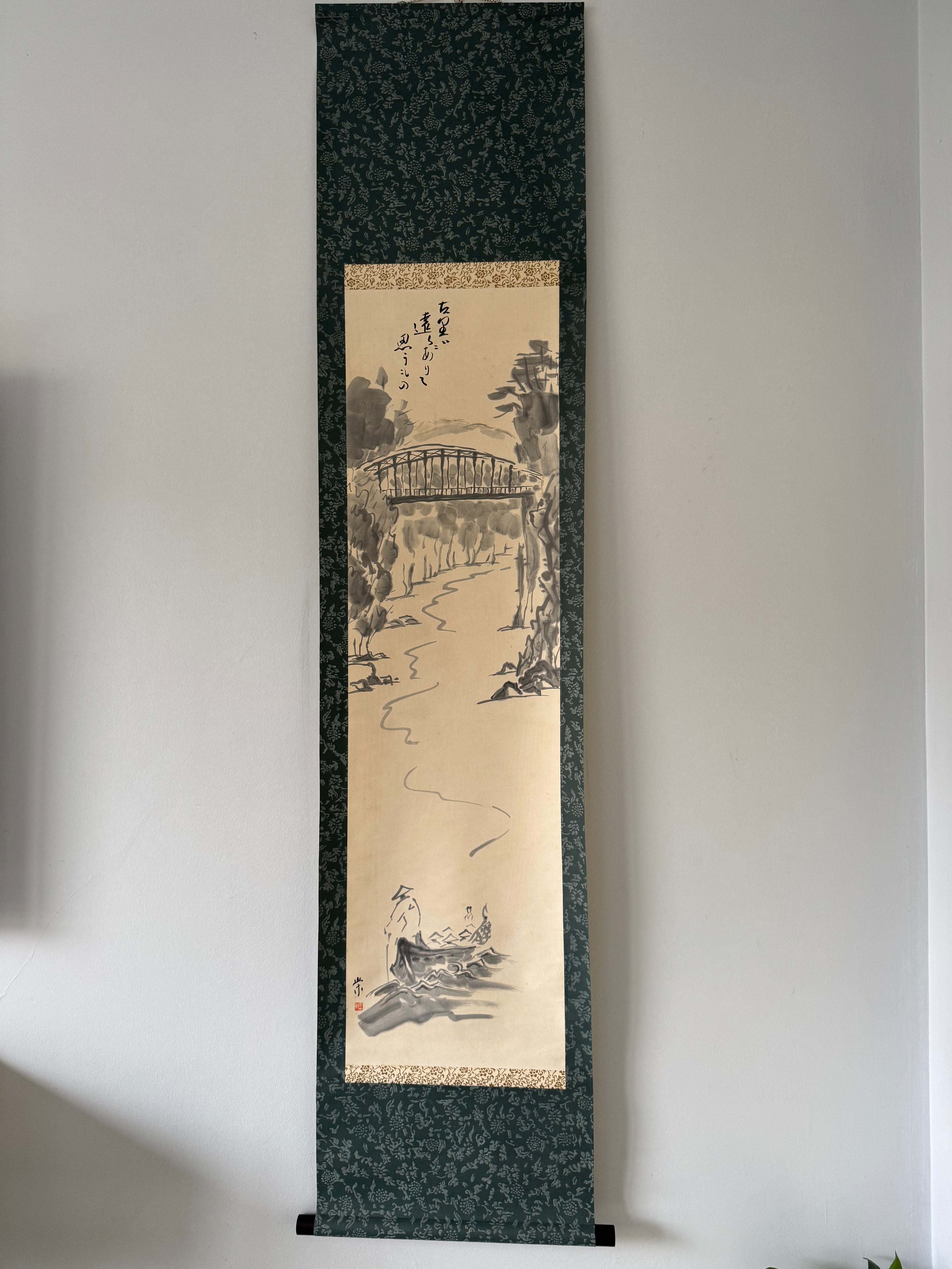 Traditional Japanese landscape scroll art on a plain wall