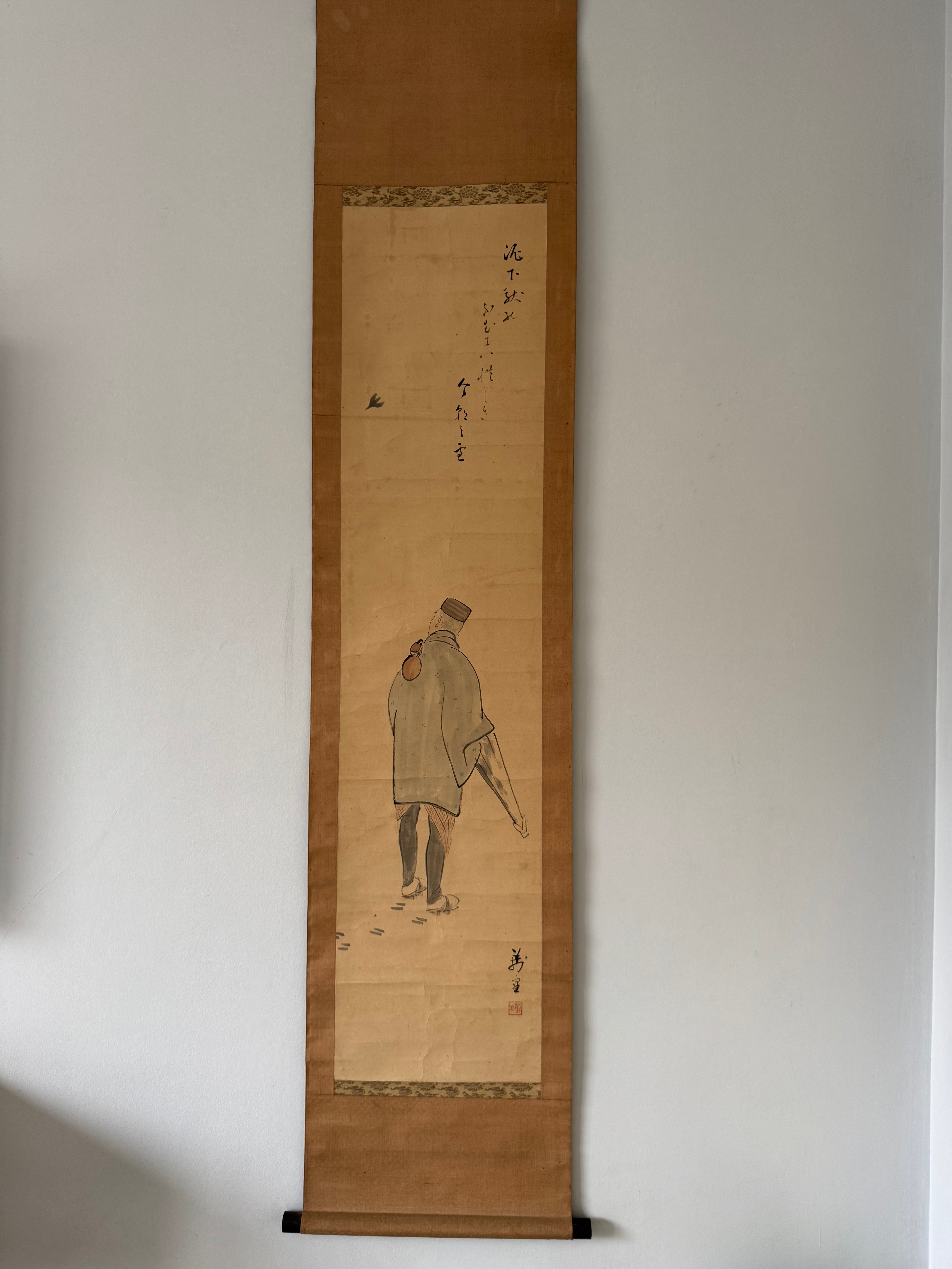 Traditional Japanese scroll painting on a plain wall