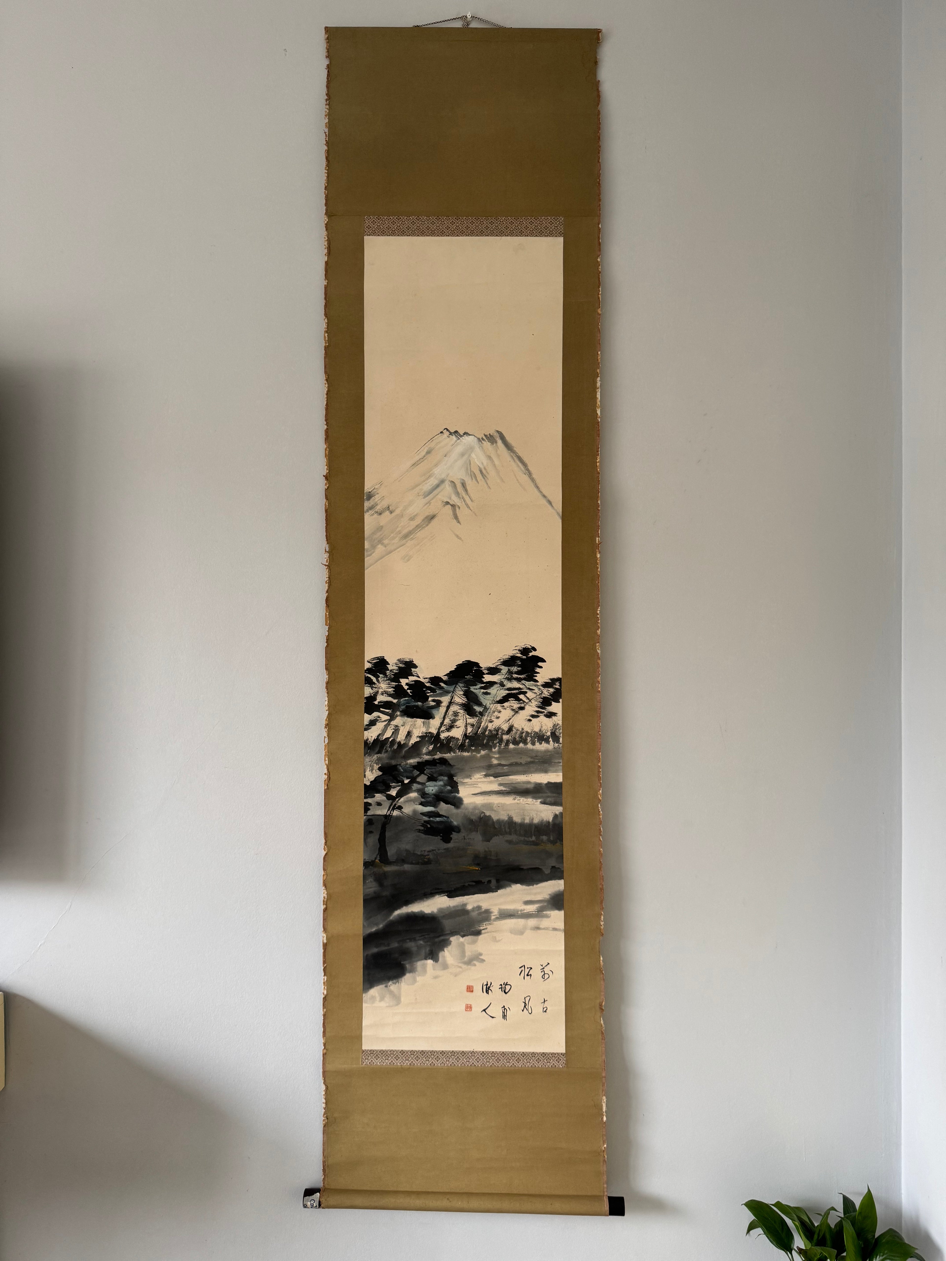 Traditional Japanese landscape scroll hanging on a wall