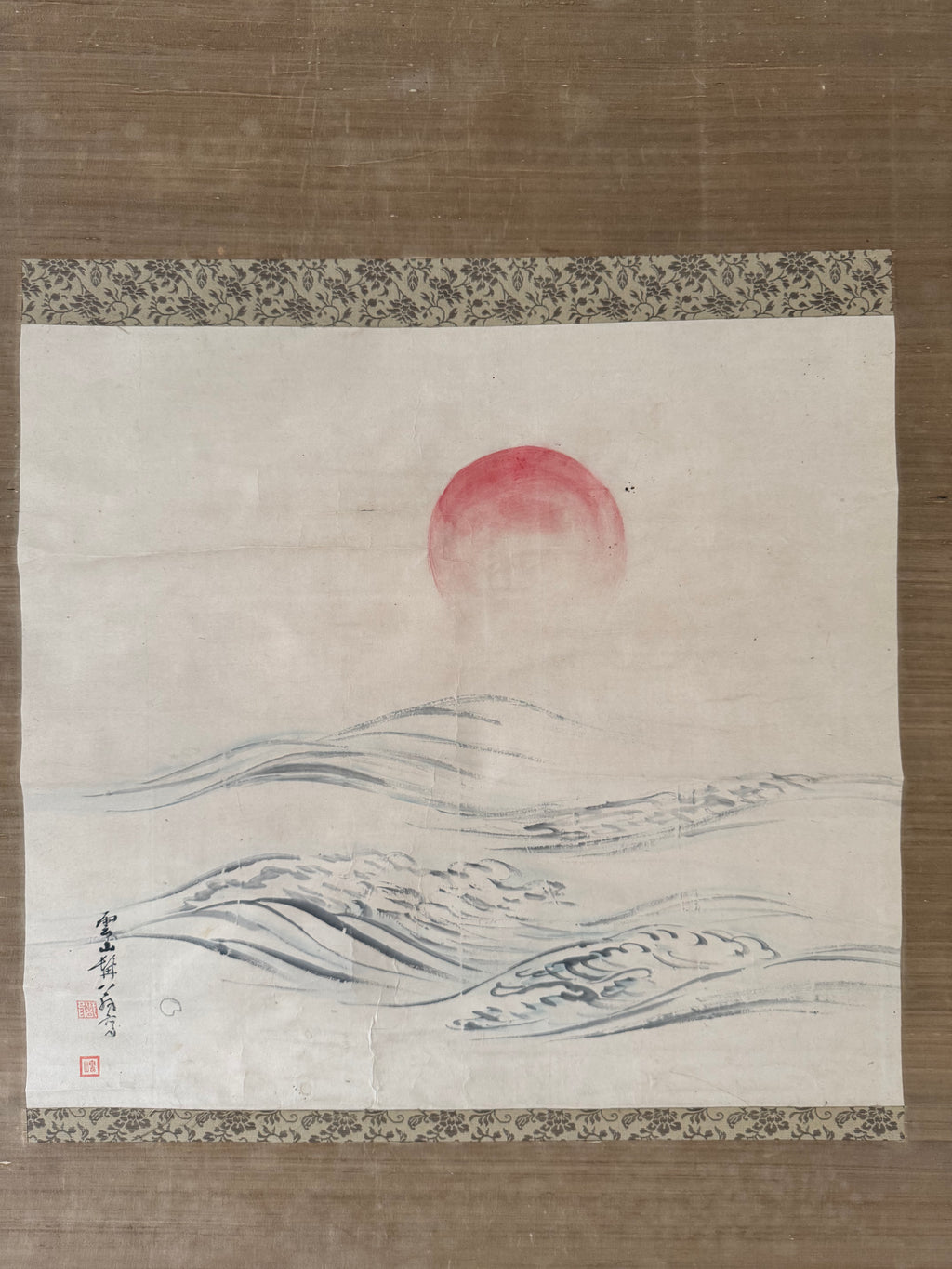 Traditional Japanese landscape with red sun and wavy lines on a textured background