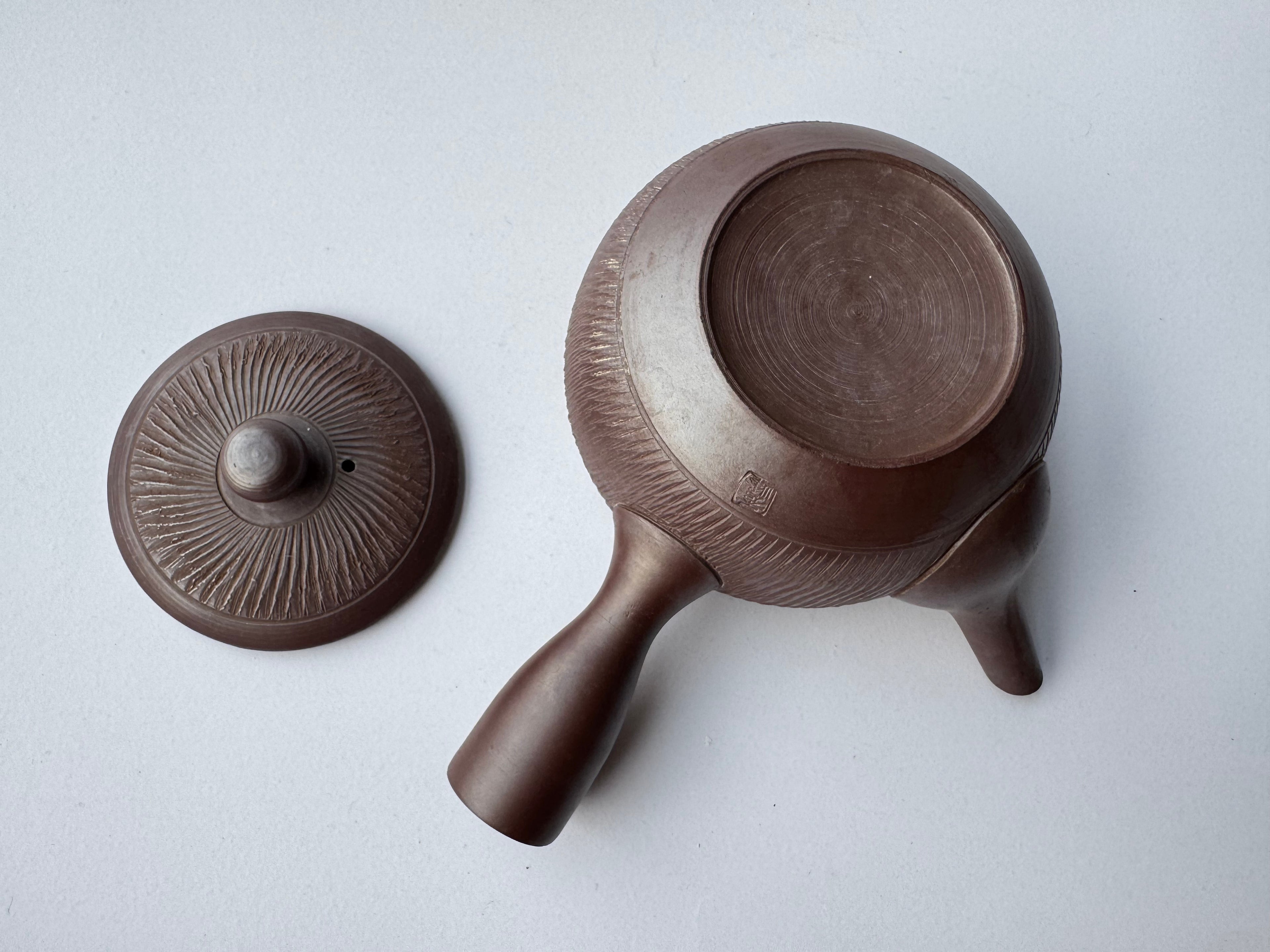 Brown ceramic pot with lid on a white background