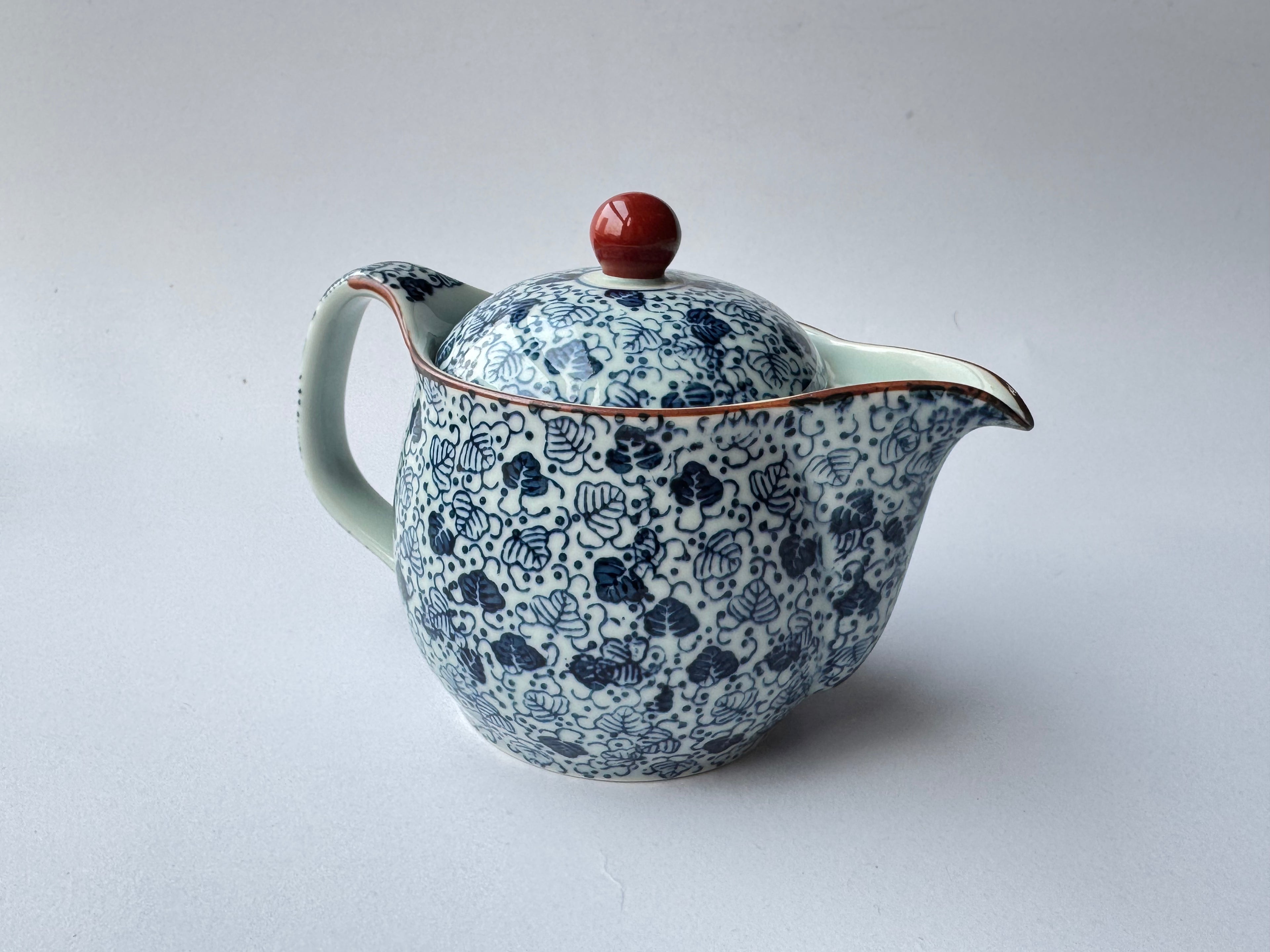 Ceramic teapot with blue floral pattern on a white background