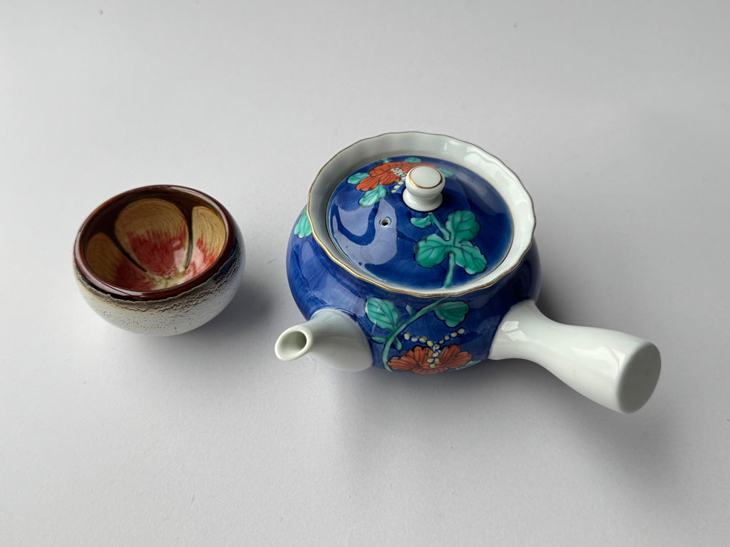 Ceramic teapot with floral design on a white background