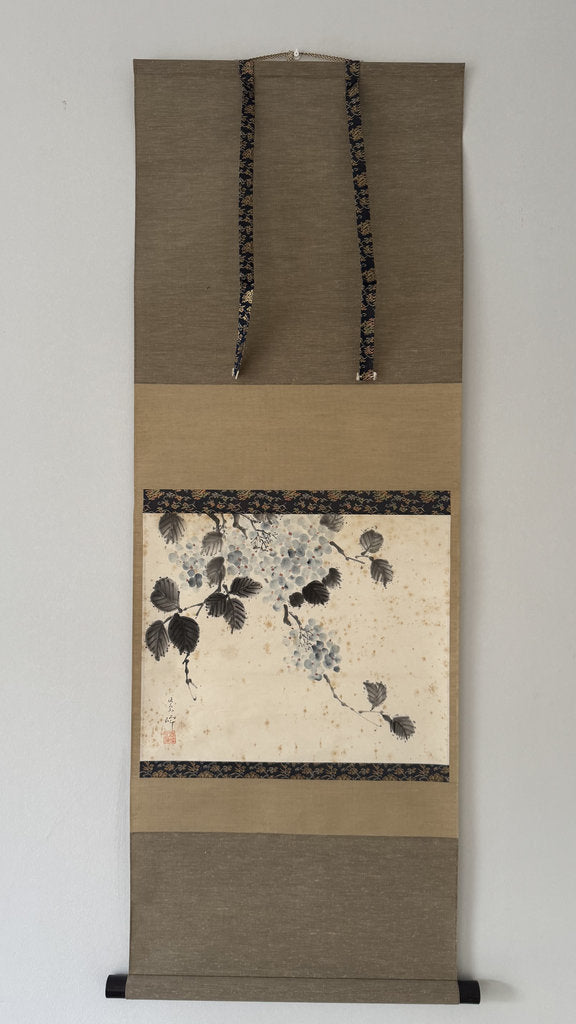 Decorative wall scroll with floral design on a plain background
