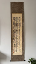Vertical scroll with calligraphy on a textured brown background