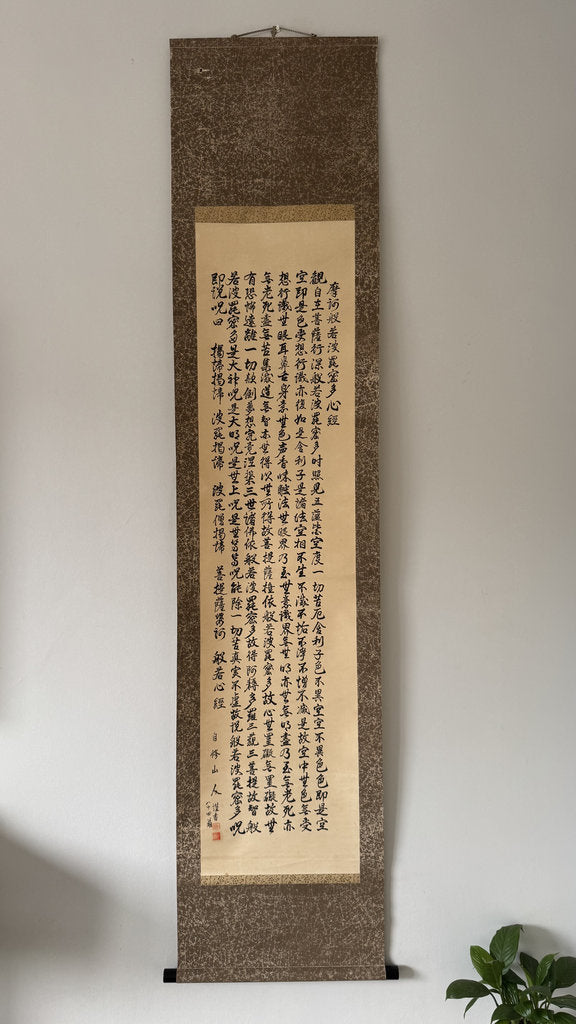 Vertical scroll with calligraphy on a textured brown background