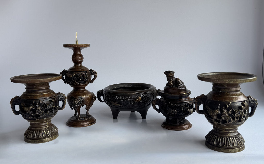 Collection of ornate bronze artifacts on a white background