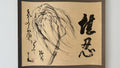 A framed calligraphic art print featuring a black ink painting of a willow branch on beige paper, with bold black Chinese characters on the right and calligraphic markings on the left, set against a light gray background.