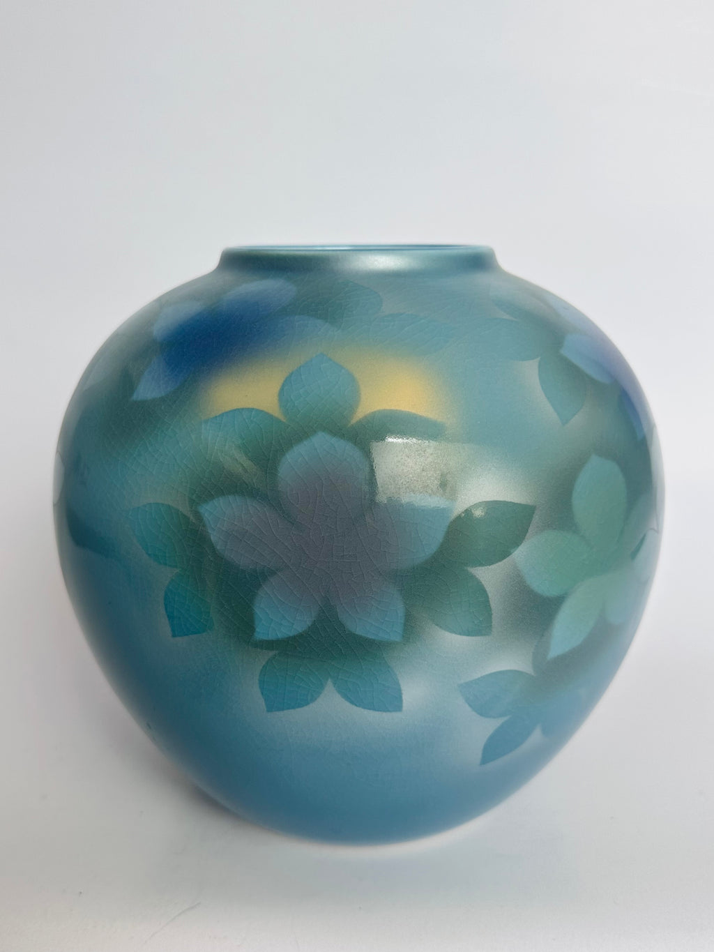 Blue ceramic vase with floral design on a white background