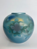 Blue ceramic vase with floral design on a white background