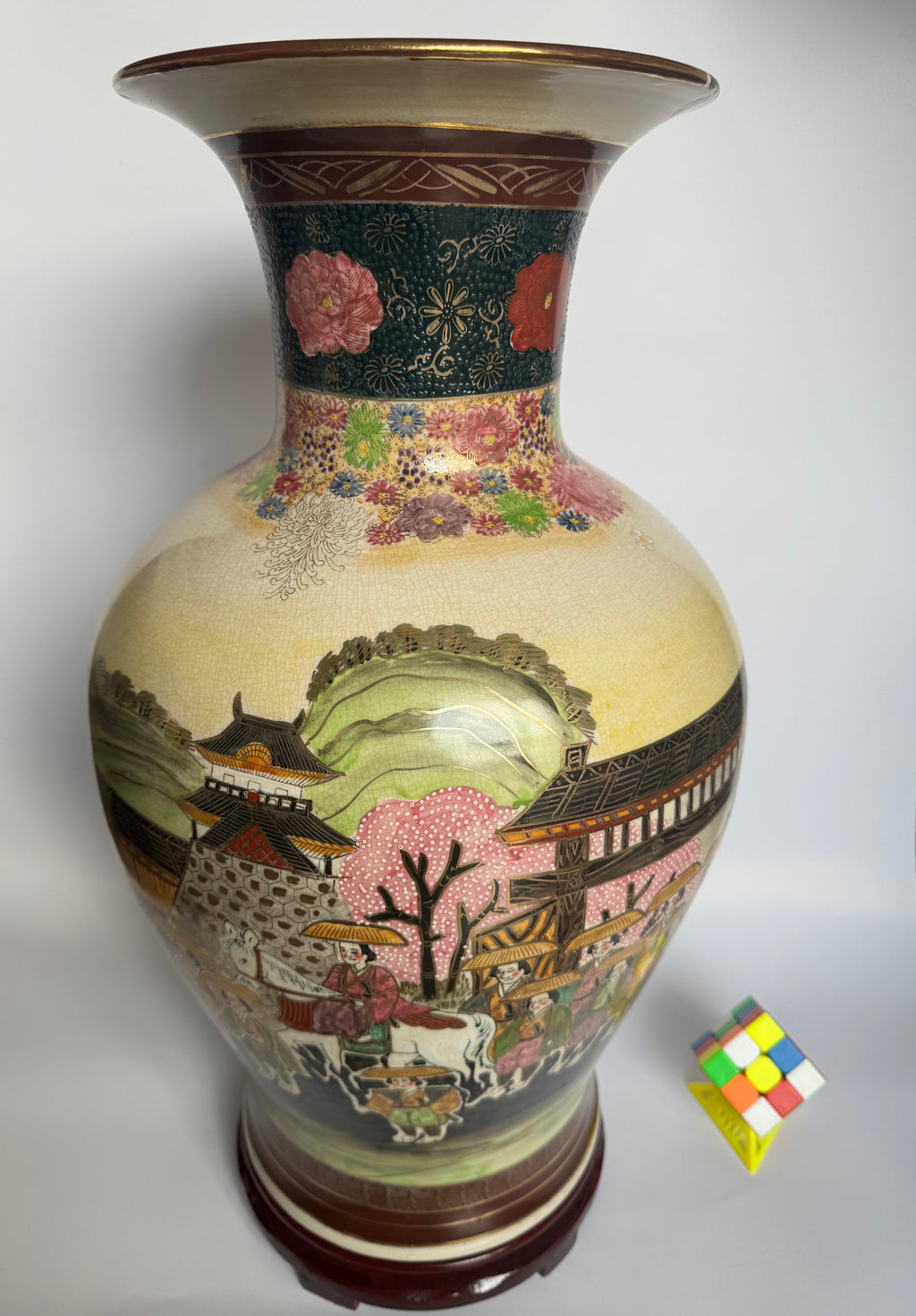 Decorative vase with floral and landscape design on a white background