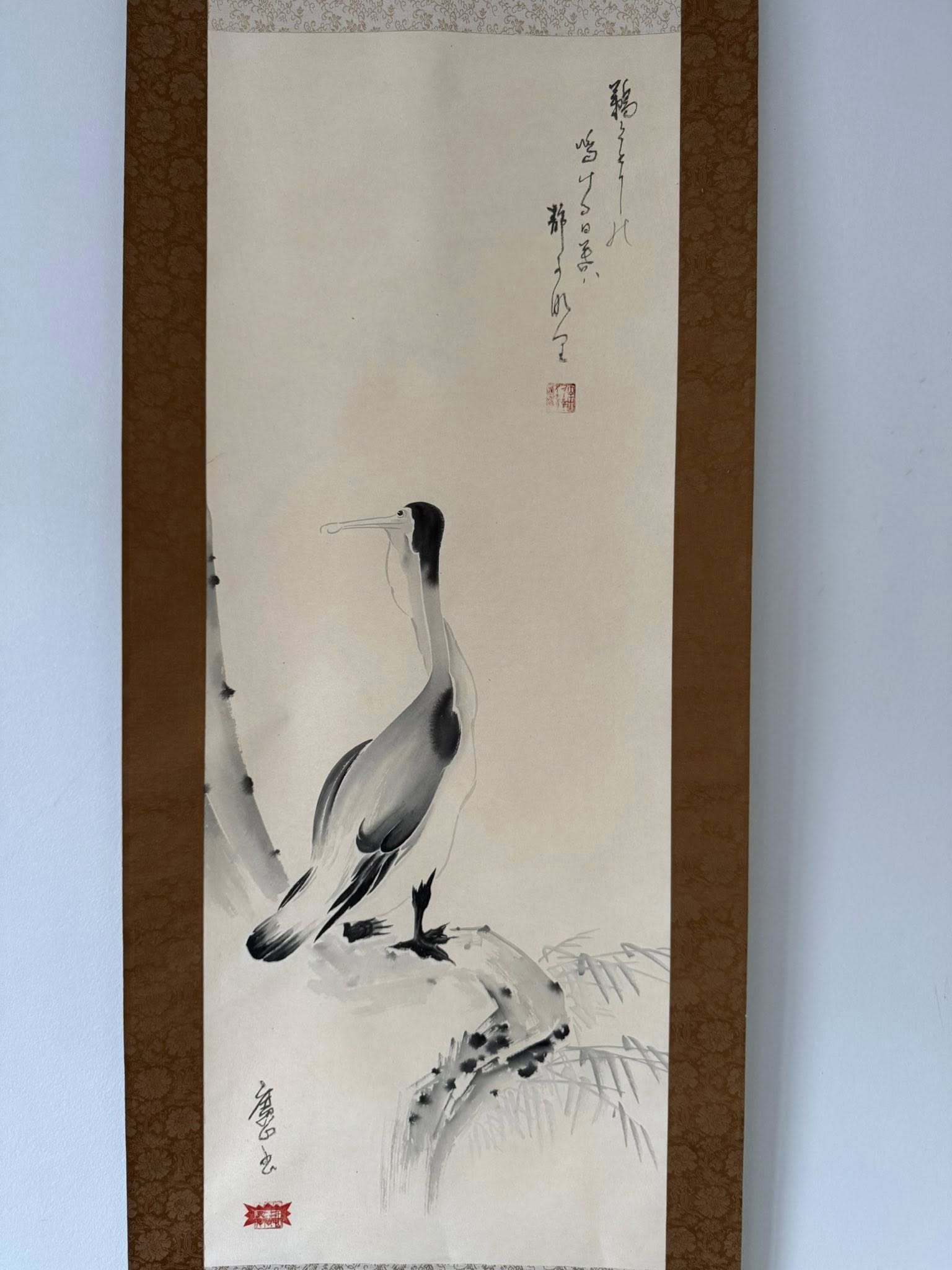 Traditional Japanese ink painting of a crane on a white background with brown frame.