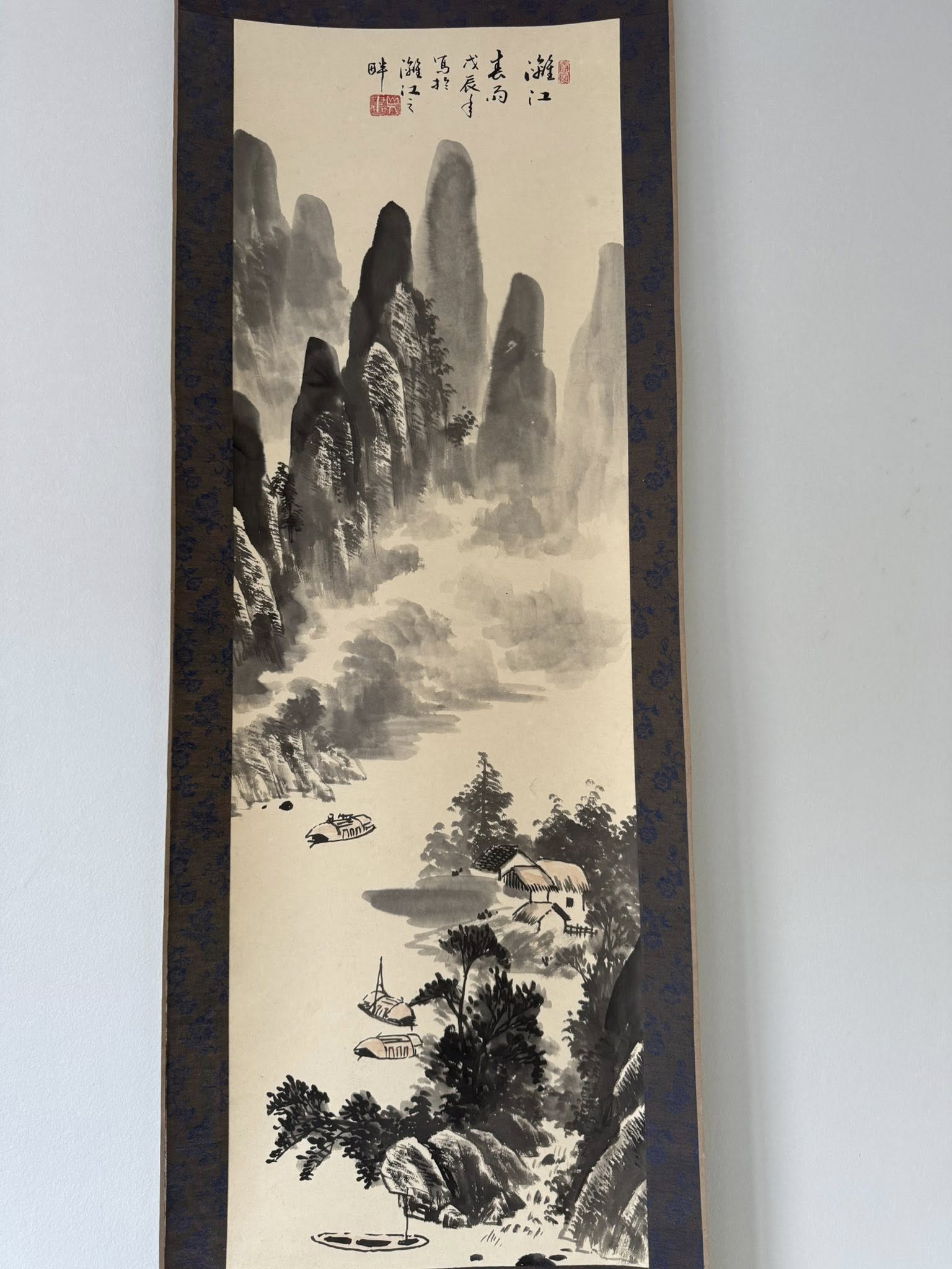Traditional Japanese landscape painting with mountains and a river on a light background