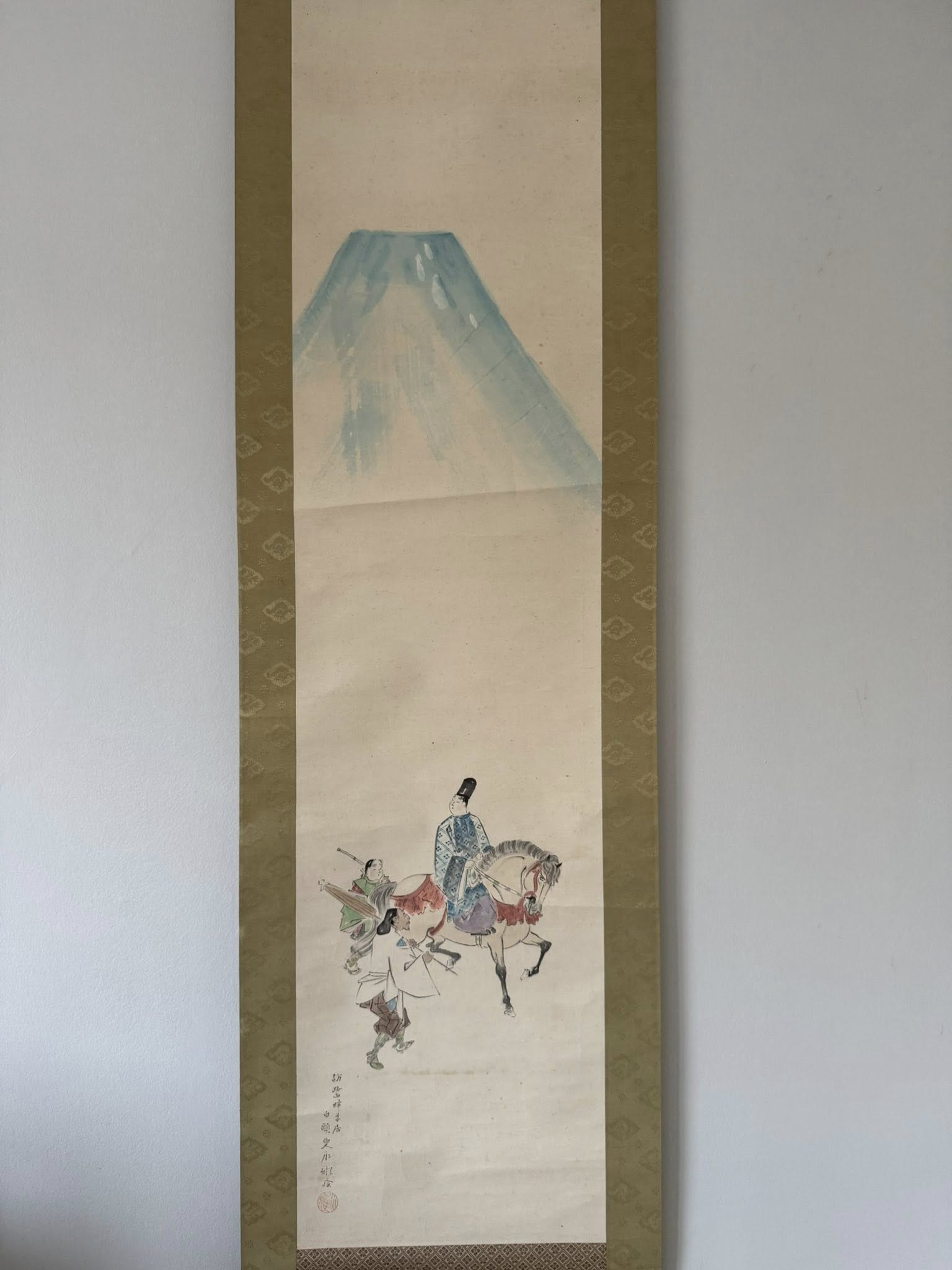 Traditional Japanese artwork of a mountain and figures on a white background with gold border